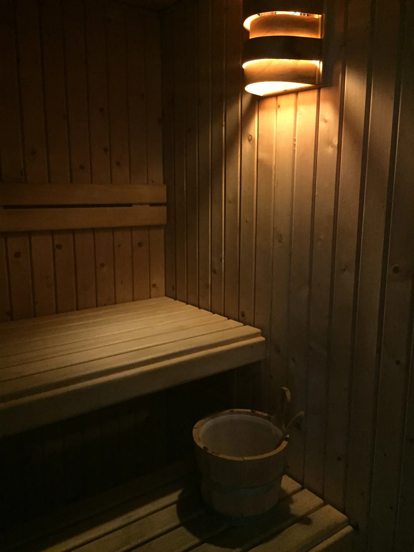 Sauna em madeira do LifeStyle SPA Coimbra, com banco, balde e iluminação quente